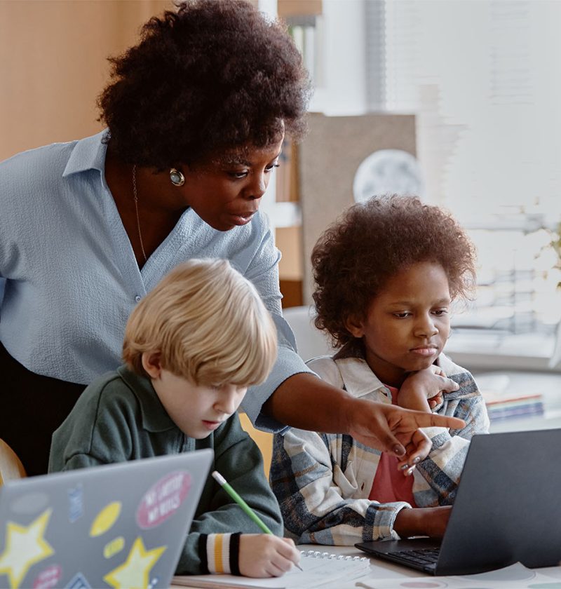 female-teacher-helping-kids-in-computer-class-2025-03-09-08-03-12-utc